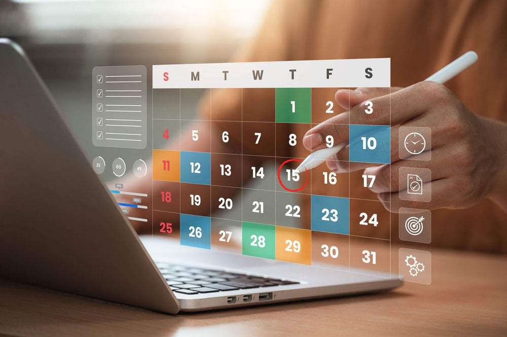 Person using a stylus to interact with a digital calendar on a laptop screen.